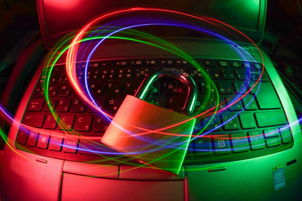 A padlock placed on a laptop keyboard with neon light effect.